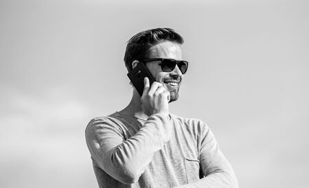 solve cases by phone. guy casual style. Fashion model. sexy man sky background. macho man use mobile phone. modern technology in life. always in touch. confident man speak on phone. Call to friendの写真素材