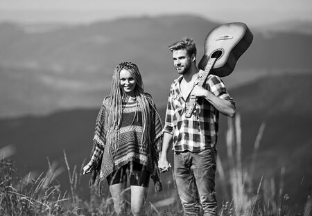 Deep in love. couple in love spend free time together. western camping. hiking. happy friends with guitar. friendship. campfire songs. country music. romantic date. men play guitar for girlの写真素材