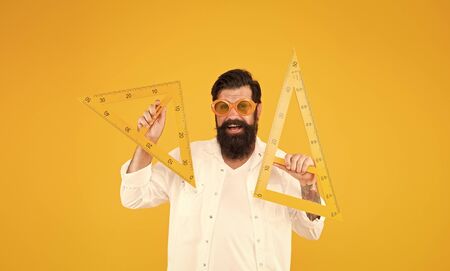 College university education. Bearded nerd triangle. Geometry teacher. Student using measuring instrument. Engineering architecture faculty student. Man math lesson. Smart student. Back to schoolの写真素材