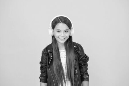 biker kid in headset. small girl in leather jacket. autumn fashion style. child listen rock music. little school radio dj. lady DJ long hair. happy smile. hipster urban style girl. lifestyle conceptの写真素材