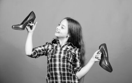 Shoes shop. Happy childhood. Glamour high heels. Awesome red stiletto shoes. Little fashionista kid with high heels. Wish to grow up faster. Every girl dreaming about fashionable high heelsの写真素材