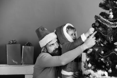 Christmas family decorates fir tree on green backgroundの写真素材