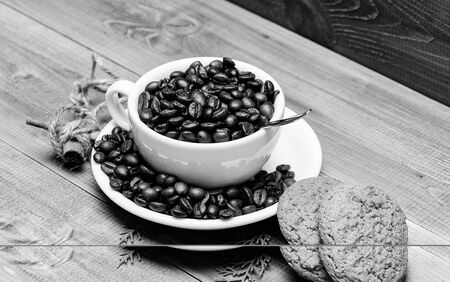 Fresh roasted coffee beans. Caffeine concept. Cafe drinks menu. Arabica robusta coffee variety. Beverage for inspiration and energy charge. Cup full coffee brown roasted bean blue wooden background.の写真素材