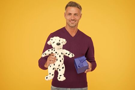 Perfect day. happy holiday shopping. present for her. man made nice purchase. cyber monday concept. handsome man with gift box and dog toy. happy valentines day. best birthday present. toy shopの写真素材