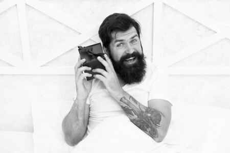 Carefree fun. valentines day. Special gift. happy hipster with present box in bed. early morning...