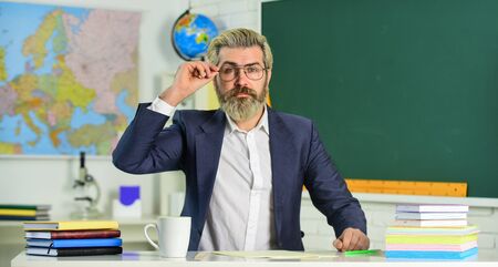 Back to school. Knowledge day. Man school teacher sit in classroom. Handsome mature smart educator....