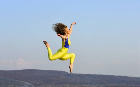 freedom is life. sport in motion. full of energy. Attractive young sporty woman is workout in outdoor gym. morning exercise. ukrainian national gymnast. Acrobatics and gymnastics. girl jumping high.の写真素材