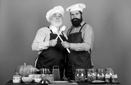 team work. cereals and seasoning. professional restaurant cook. mature senior bearded men in kitchen. Halloween pumpkin recipe. Chef men cooking. cheerful men prepare food. Healthy food cookingの写真素材