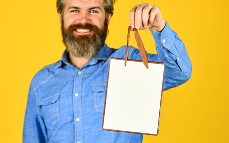 Retail concept. Hipster buying sale price. Cyber monday sale. Nice purchase. Bearded man hold shopping bags. Handsome buyer. Seasonal sale. Special offer. Happy birthday. Buy gift. Black Fridayの写真素材