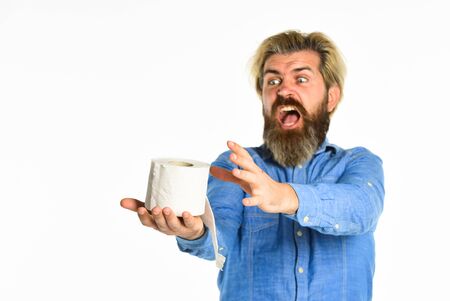 oh no. fear of pandemic outbreak closing shopping stores. man hold tissue roll in toilet. bearded man hold toilet paper. guy suffer from diarrhea. toilet paper shortage in coronavirus panicの写真素材