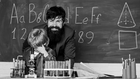 Knowledge day. My father is scientist. Teacher bearded man father and child test tubes. Study chemistry together. Boys only. Personal example. Chemical experiment. Following father in everythingの写真素材