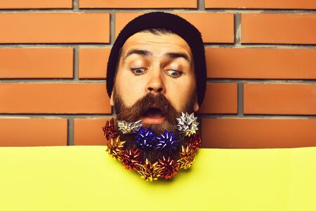 Bearded man, brutal caucasian surprised hipster with gift decoration starsの写真素材