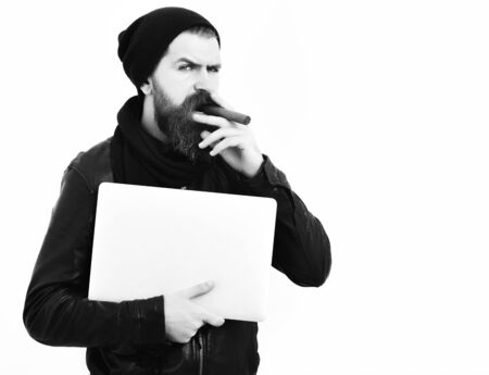 Bearded brutal caucasian hipster holding laptop and smoking sigarの写真素材