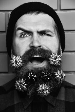 Bearded man, brutal caucasian squinting hipster with gift decorative starsの写真素材