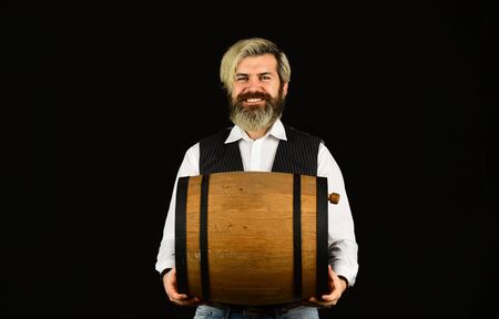 Winery concept. Producing wine family tradition. Man bearded hipster wooden barrel for wine black background. Homemade wine. Fermentation product. Advice on Buying Old and Rare wines. Natural wineの写真素材