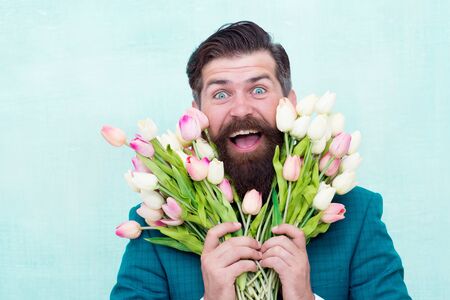 Spring in my head. flower surprise for her. bearded man in formal suit greeting. happy valentines day. womens day gift tulips. spring flowers. Man with bouquet tulips. prepare for mothers day holidayの写真素材