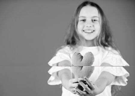 Love concept. Girl cute child show heart toy. Heart symbol of love. Romantic feelings. Kid adorable girl happy face play heart blue background. Celebrate valentines day. Love heart holiday decorの写真素材