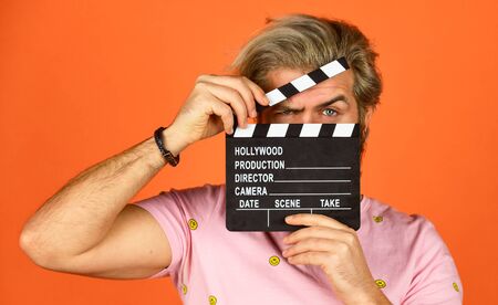 Cinema production. Creative producer. Bearded man hold movie clapper. Film maker. Clapperboard copy space. Comedy or drama. Watch movie. Film director. Actor casting. Shooting scene. Favorite series.の写真素材