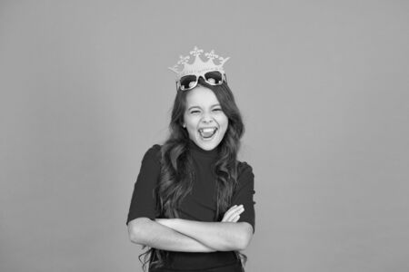 Keep celebrating. Happy girl enjoy celebrating orange background. Little child wear prop crowm and glasses. Celebrating birthday anniversary. Celebrating success. Party celebration. School promの写真素材