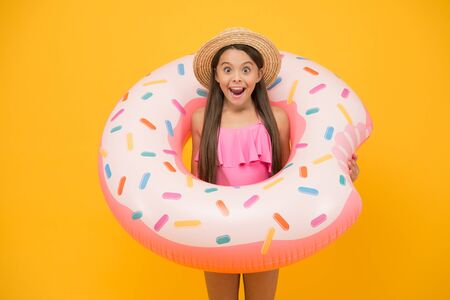 Surfing in the sea. little girl and rubber ring. surprised kid in swimwear at swimming pool. summer...
