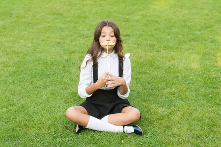 Ready for school party. Little child hold mustache props green grass. Small girl with photobooth props on stick. Party props and accessories. Perfect props for farewell celebration. Summer holidaysの写真素材