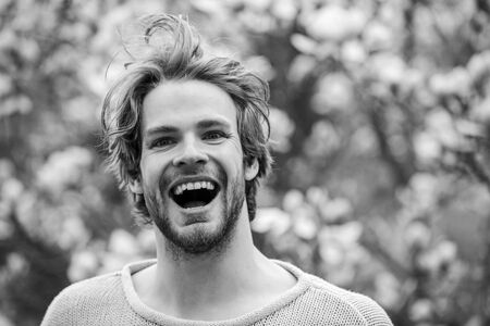 feel refreshed. easter. sakura smell. enjoy good weather. allergy. happy man at blooming magnolia flower tree. spring holiday. healthy youth. relaxing in morning. man near flowering treeの写真素材