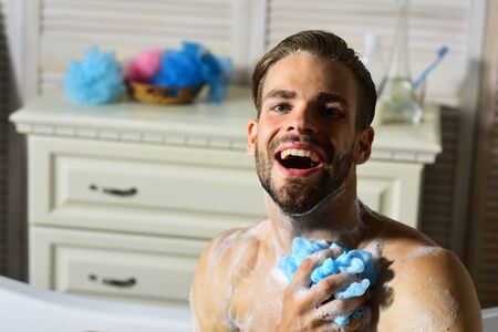 Man with beard in bathtub laughing wide