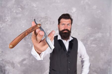 Grooming routine. Facial care. Straight razor is razor with blade that can fold into its handle. Shaving man. Hair salon. Vintage and classic. Hair beard care. Handsome brutal man shaving hairの写真素材