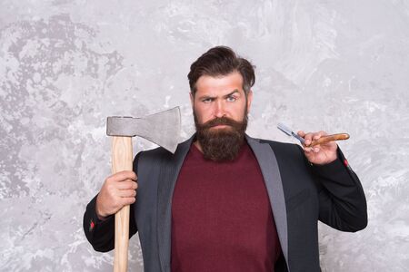 Proper tools. Brutal methods. old weapon. Barbershop hairstyle. Brutal barber. Daring barber concept. Man hipster with axe. Sharp ax and straight razor. Masculinity and brutality. Vintage barbershopの写真素材