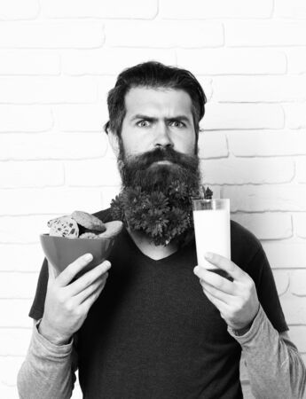 hipster with flowers in beard on white brick wall backgroundの写真素材
