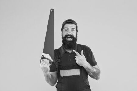 carry out repairs. build and construction. Skilled architect repair and fix. engineer worker career. brutal male worker with saw. man builder yellow background. professional repairman in uniformの写真素材