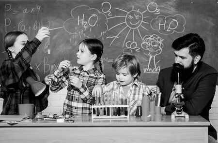 Chemistry themed club. Interests and topic club. Group interaction and communication. Share interests hobbies talents and skills. School club education. Teacher and pupils test tubes in classroomの写真素材