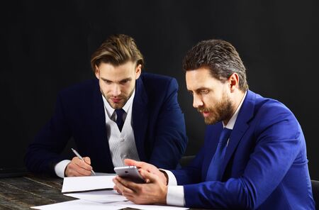 Business partners look at smartphone. Support, start up, financial agreement, technology and innovations concept.の写真素材