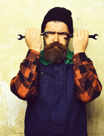 Bearded brutal caucasian mechanic holding metallic wrenchesの写真素材