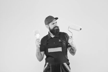 Skilled architect repair and fix. bearded worker. Hard worker with painting brush and roller. Construction worker ready to work. brutal hipster try to be craftsman. serious builder manの写真素材