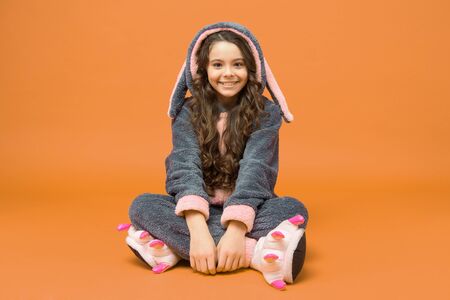 Cute baby. Domestic clothes. Rest and relax. Cute bunny kid. Baby animal character. Smiling Girl in bunny costume. Child rabbit kigurumi. Happy girl bunny pajamas. Smiling kid. Clothes shopの写真素材