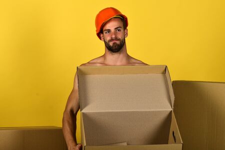 Sexuality and building concept: man standing naked with empty box