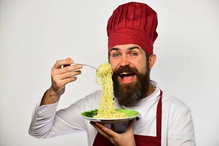 Cook with happy face in burgundy uniform holds noodles