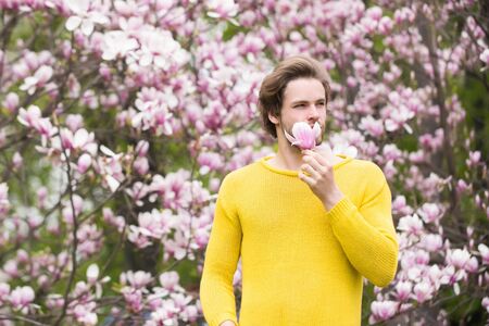 Flourishing and growth Macho with beard in yellow sweater on floral background.の写真素材