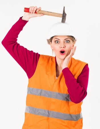 Woman on shocked face knoks with hammer on head, isolatedの写真素材