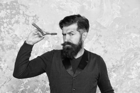 hipster shave face with blade. confident man beard. brutal hairdresser master. bearded barber ready for shaving. everyday gomming. personal care and hygiene. Barbershop retro equipments and toolsの写真素材