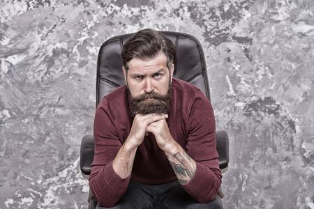 Why so serious. Caucasian man look thoughtful. Bearded man with unshaven beard hair on caucasian face. Caucasian hipster sit in chair. Caucasian european guy wear casual style, vintage filterの写真素材
