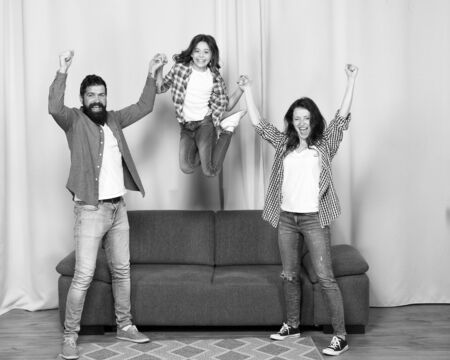 move in new house. full of energy. childhood happiness. happy family day. spending time together. happy people jump from feel of freedom. mother father and daughter having fun at home. Living betterの写真素材