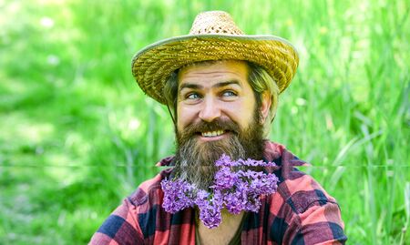 flower in hair. relaxed farmer in straw hat. mature man gardener relax on green grass. enjoy spring...