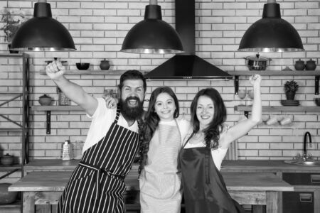 Vegetarian concept. everyday winners. Mother and father cooking with daughter. happy family day. friendly family in kitchen. healthy food at home. kid cook dinner with parents. do everything togetherの写真素材