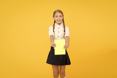 Schoolgirl wear school uniform. Knowledge day. Girl with copy book or workbook. Kid student ready with homework. School girl excellent pupil prepared essay or school project. Raising independenceの写真素材