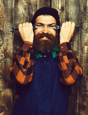 Bearded brutal caucasian mechanic holding metallic wrenchesの写真素材