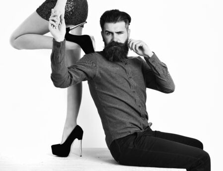 bearded man with sexy female legs has serious faceの写真素材