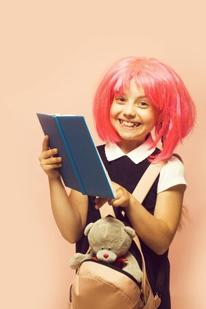 Schoolgirl with pink wig on light pink backgroundの写真素材