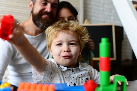 Boy builds out of plastic blocks on light background,の写真素材